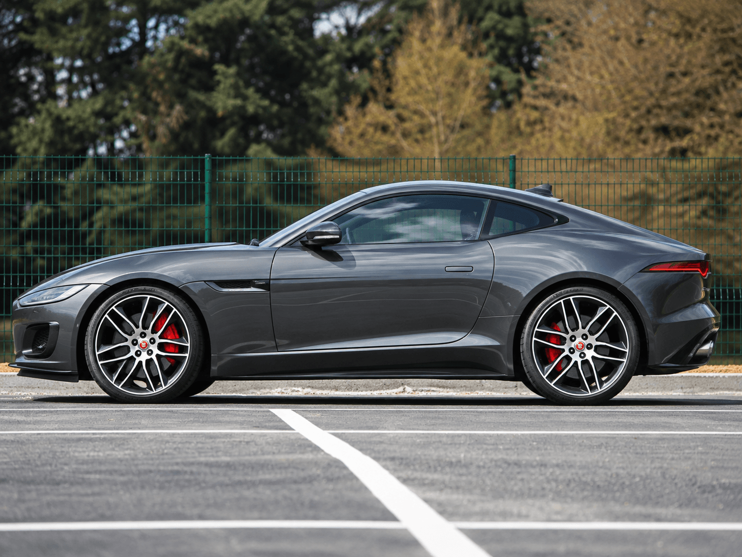 Unprepared gray Jaguar F-Type photographed from the side outdoors